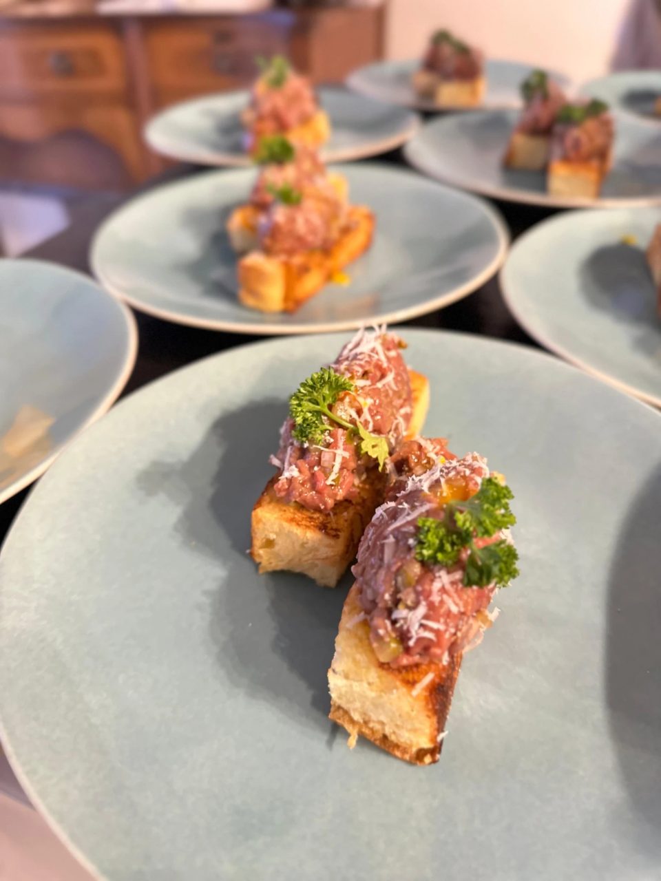 Beef tartare crostini canapés with parmesan and parsley