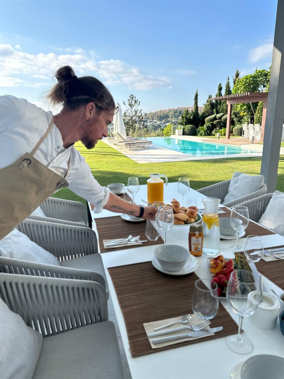 Christian Wybaux serving breakfast at a poolside villa table in Marbella