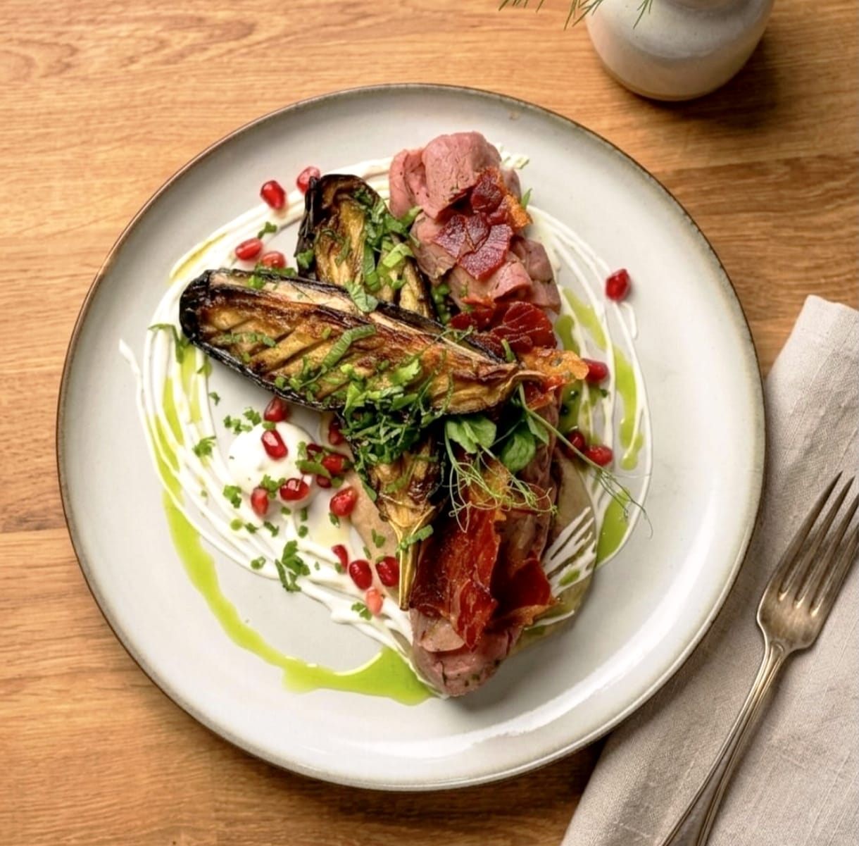 Lamb with roasted aubergine, pomegranate and crispy jamón