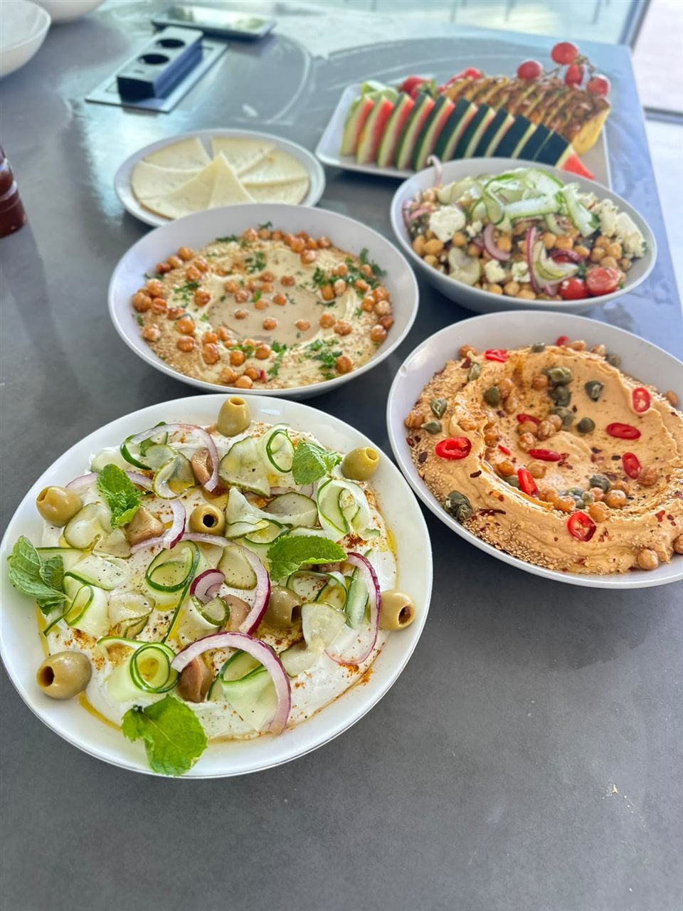 A mezze sharing spread with hummus, labneh and salads
