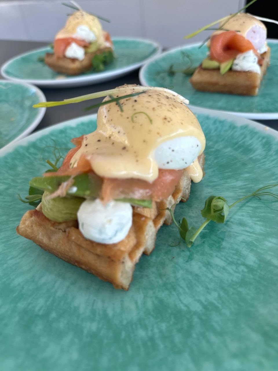 Smoked salmon and poached egg benedict on a waffle with hollandaise