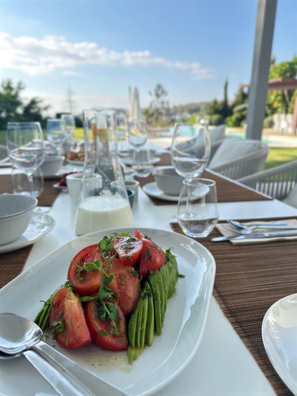 Heritage tomato and avocado salad on a sunny terrace table